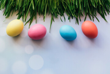 Easter background with Easter eggs and spring grass. Row of easter eggs in fresh green grass.
