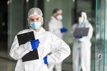 Confident expert virologist doc center clinic holding blank wear face mask hazmat blue uniform suit plastic facial goggles in hospital