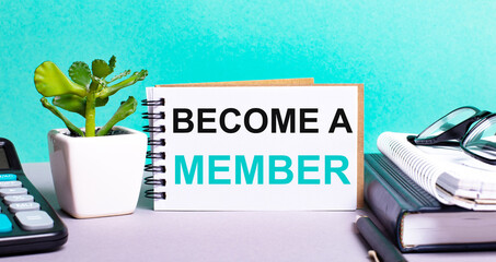 BECOME A MEMBER is written on a white card next to a potted flower, diaries and calculator....