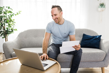 Handsome man paying online using a laptop