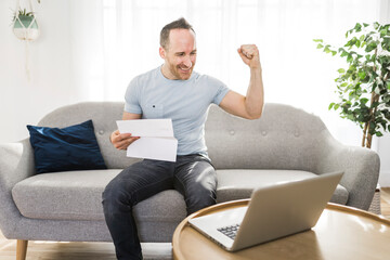 Handsome man paying online using a laptop