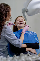 Professional doctor dentist examine and treat spoiled teeth with the use of special dental...