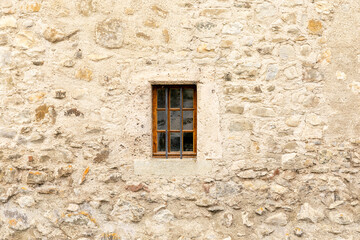 Fototapeta na wymiar Castle window, built within a sturdy stone wall.