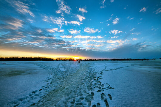 Sunset over Frozen Lake with frozen footprints