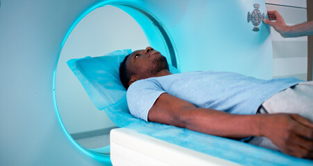 African American patient entering CT machine in clinic
