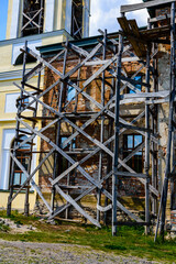 Wooden scaffolding near the old building. Ancient building restoration