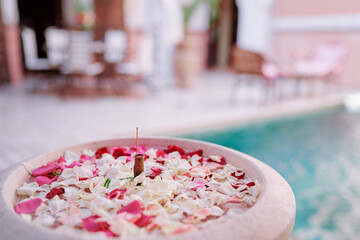 Fountain bowl with roses petals.