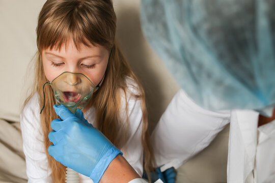 The doctor holds a breathing mask for the child, helps to breathe with an inhaler, oxygen mask, nebulizer