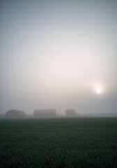 Silhouettes of Countryside Buildings in an Early Morning Fog