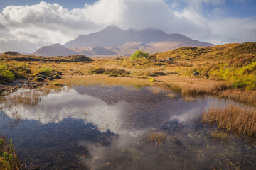 Reflection of the Black Cuillins mountain landscape in a small tarn at Sligachan on the Isle of Skye in the Scottish Highlands, Scotland.