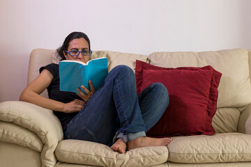 a girl enjoying a book on a sofa