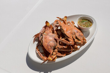 grilled crab on a white plate with seafood dipping