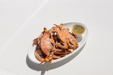 grilled crab on a white plate with seafood dipping