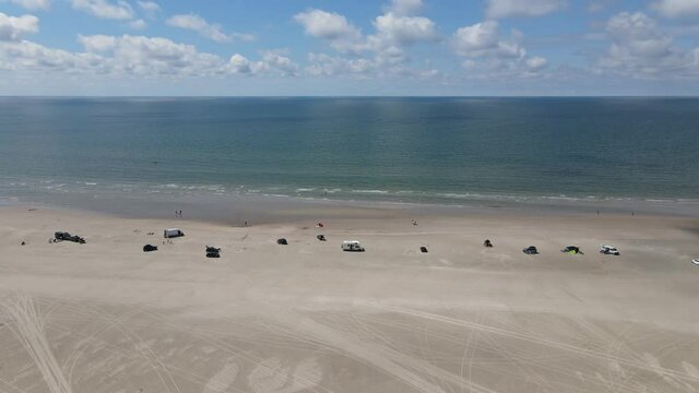 Beach aerial with cars and tourists. Moving towards ocean. Fanoe, Denmark