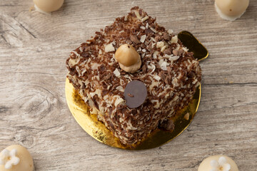 slice of cake with chocolate decoration and a walnut, around white chocolate balls, elegant dessert in studio