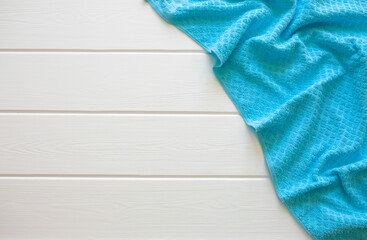 A blue terry towel lies on a white wooden table. Cleanliness and hygiene. Bathroom. Sun lounger by the pool, spa treatments.