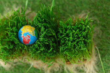 A globe on the lush green grass. Earth Day.