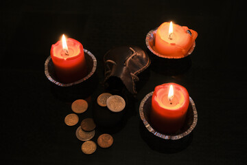 Euro coins dropped from the leather bag near the candles