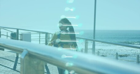 Animation of dna strand spinning over woman walking with electric scooter by seaside - Powered by Adobe