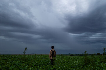 Hombre en medio del campo en día nublado