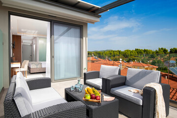 Summer panoramic view of roof top open terrace with wicker furniture in modern studio room apartment of European resort hotel