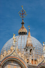 Fototapeta na wymiar Decoration elements at roofs and cupolas of Basilica San Marco in Venice, Italy, at sunny day and deep blue sky