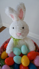 Easter bunny in a basket with colorful plastic Easter eggs