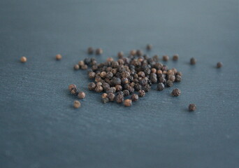 Black pepper  (Piper nigrum), peppercorn  on grey background
