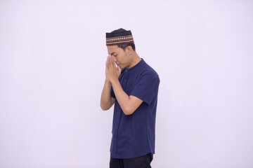 young asian muslim praying to the God isolated white background