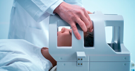 Crop doctor preparing boy for MRI procedure in lab