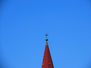 Close-up view of the top of a church against the blue sky in Acre, Israel. The cross is a symbol of the Christian religion.
