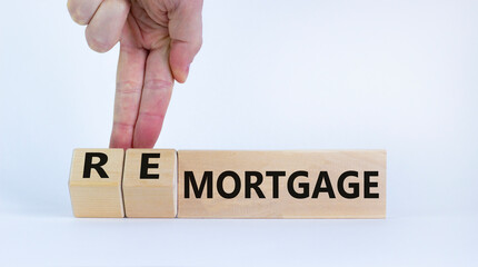 Mortgage or remortgage symbol. Businessman turns cubes and changes the word 'remortgage' to 'mortgage'. Beautiful white background, copy space. Business, Mortgage or remortgage concept.