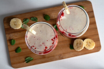 Fototapeta na wymiar Two glasses with strawberry banana dessert.