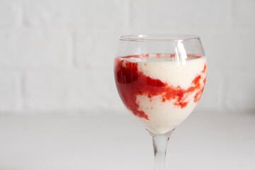 glass with creamy banana strawberry dessert.