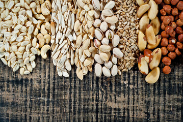 Many kinds of nuts close up. Heap of nuts on a black wooden board. Nuts are stacked on the table.