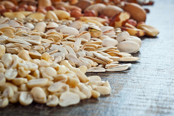 Many kinds of nuts close up. Heap of nuts on a black wooden board. Nuts are stacked on the table.