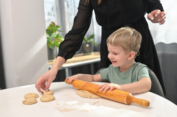 Mother With Toddler Son With Cochlear Implants Baking Donuts - 417895406