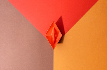 small red paper boat on a paper background. conceptual abstract image of the female genital organs...