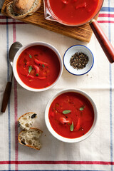 Tomato soup in a white bowl on white background. Top view. Copy space