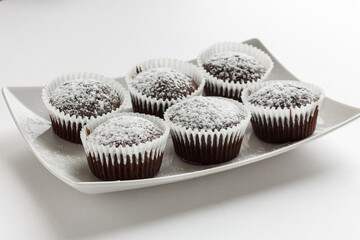 Several chocolate muffins on the white square plate