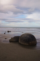 Obraz premium The Moeraki Boulders are unique large round stones lying along of Koekohe Beach in New Zealand