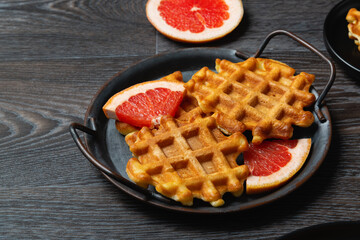 Waffle breakfast with grapefruit on a wooden table