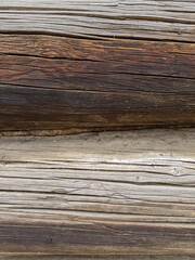 close-up as a background - the texture of an abandoned wooden house, a wall of old wooden blackened beams with slots, horizontally folded, connected by tow. In the countryside, outside the city. 
