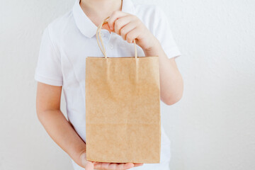 Save the planet. The boy holds a paper bag in his hands. Eco-packaging.