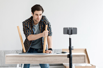 Young male repairman recording video for blog at free time