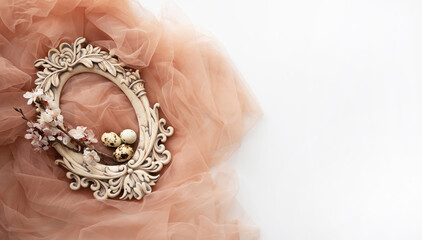Old oval carved frame with spring flowers and eggs on pastel background. Spring flowers composition with copy space.