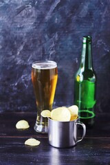 Patrick's day, beer, chips in an iron mug, shamrock on a dark background, party, congratulations, postcard