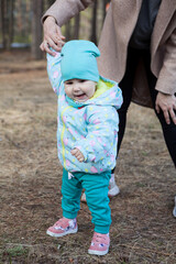 Smiling enjoying kid learning to walk with mother assistance, family relation
