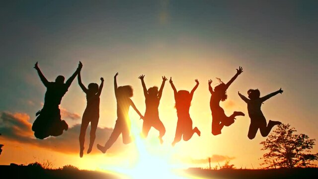 Silhouette of friends jumping in sunset