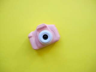 Plastic rose camera on yellow background, children playing,  kids games, how to become a photographer, taking pictures since childhood, hobby